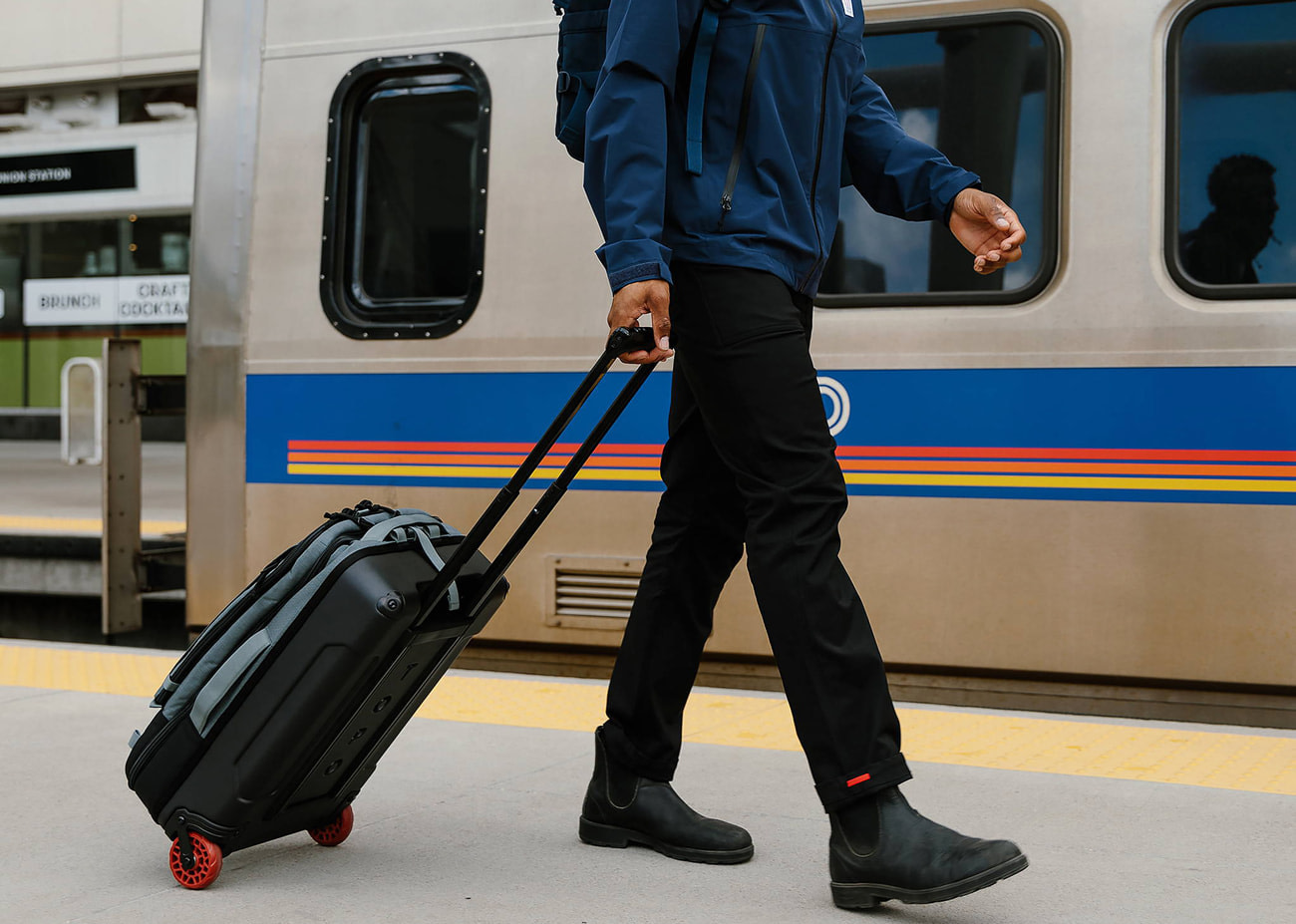 Suitcase with stowable backpack straps